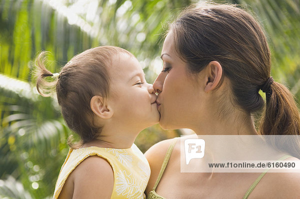 Hispanische Mutter kissing baby