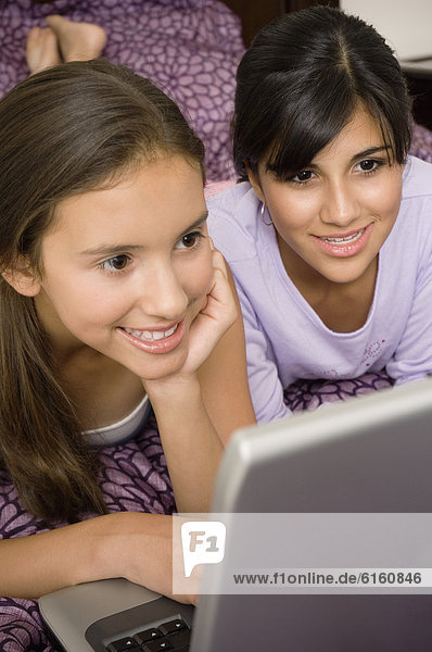 Multi-ethnic girls looking at laptop