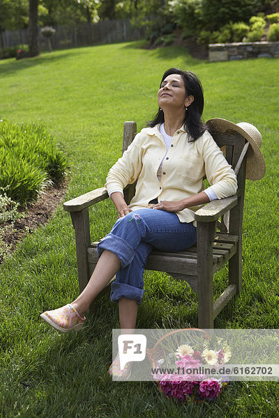 Hispanic woman relaxing in backyard