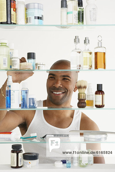 African American man looking in medicine cabinet