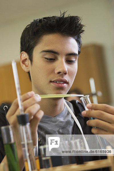 Hispanic teenaged boy in science class