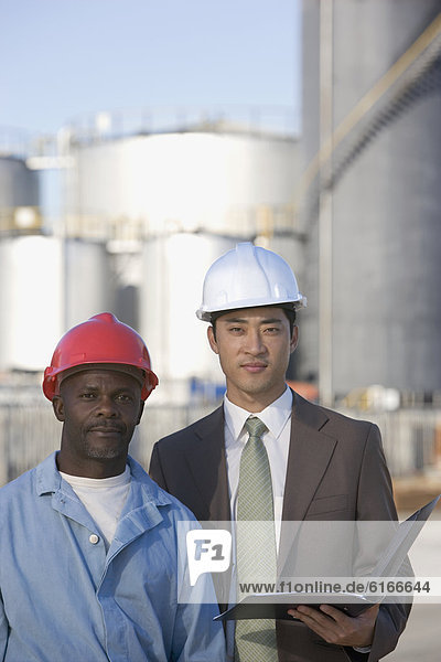 Multi-ethnic businessman and construction worker wearing hardhats