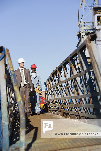 Multi-ethnic businessman and construction worker walking
