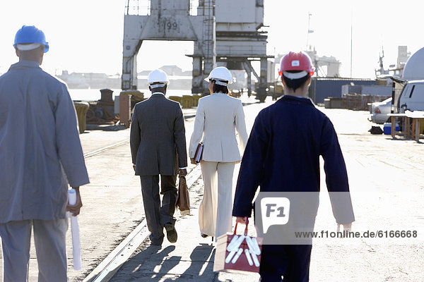 Multi-ethnic businesspeople and construction workers walking