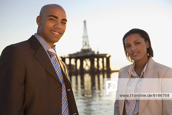 African American businesspeople in front of shipping crane