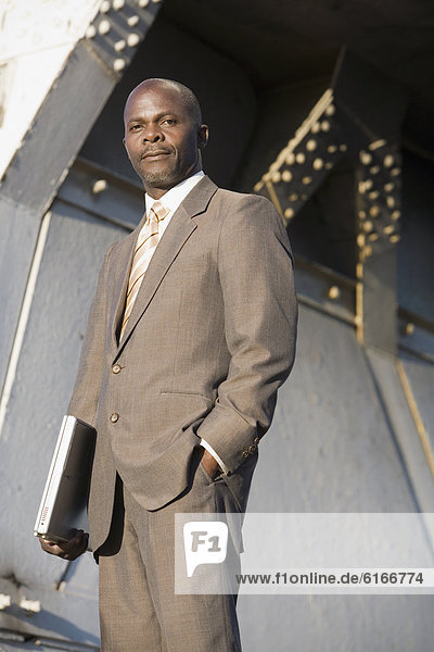 African American businessman holding laptop