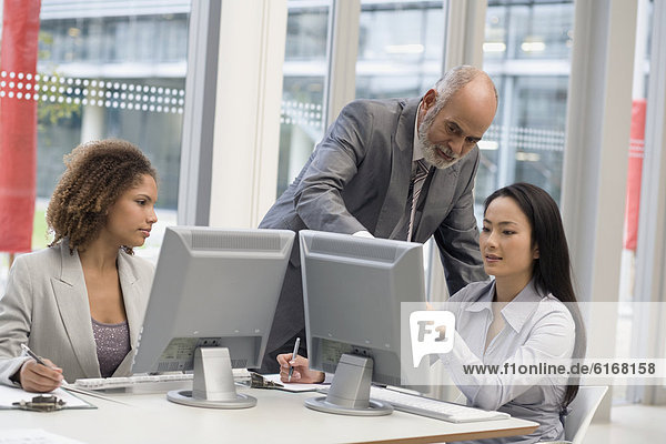 Multi-ethnic businesspeople looking at computer