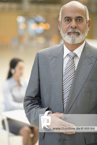 Senior African businessman with hand on jacket