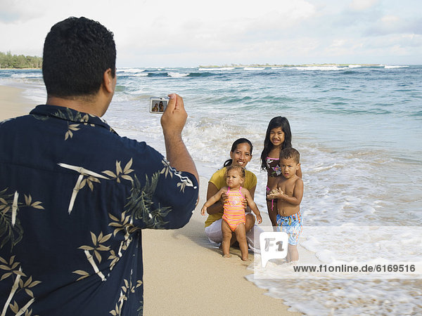 Pacific Islander father taking photograph of family