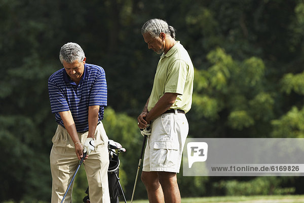 Multi-ethnic men playing golf