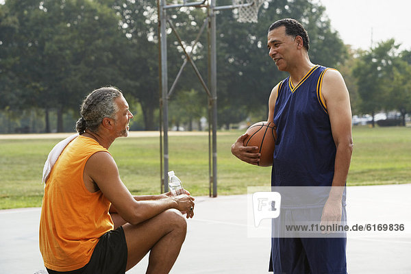 African men talking on basketball court