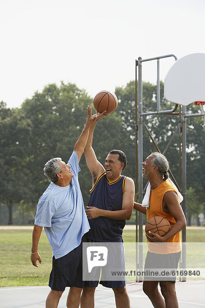 Multi-ethnic men playing basketball