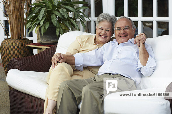 Senior Hispanic couple sitting on sofa