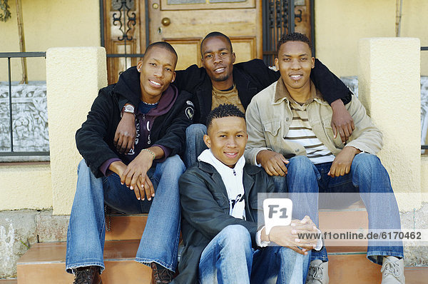 African men sitting on porch steps