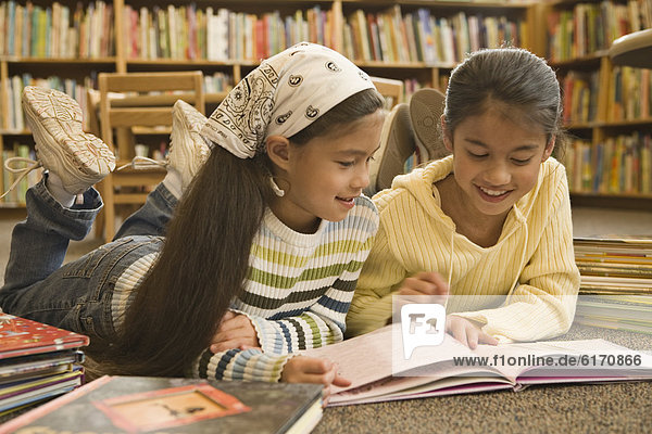 Pacific Islander girls reading in library