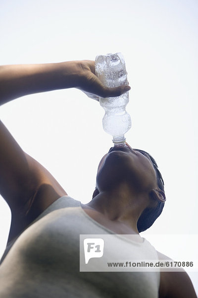 African woman drinking water bottle