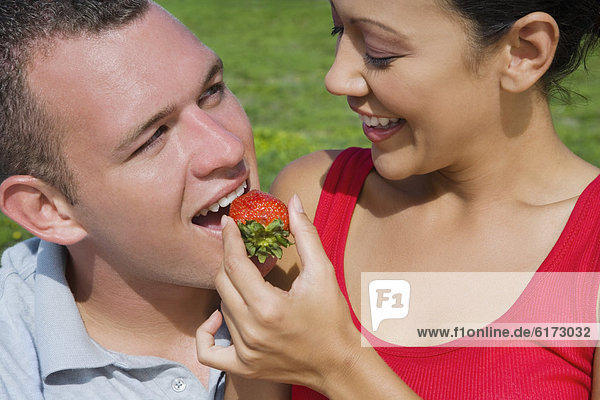 African man pulling shorts off woman in bikini - Stock Photo - Dissolve