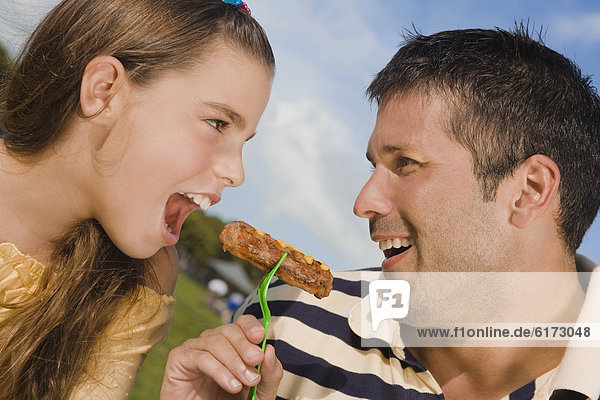 Hispanic father and daughter eating from same fork