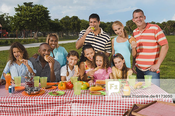 Multi-ethnic friends eating at picnic table