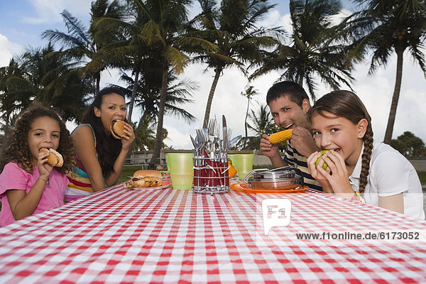 Hispanic family eating at picnic table