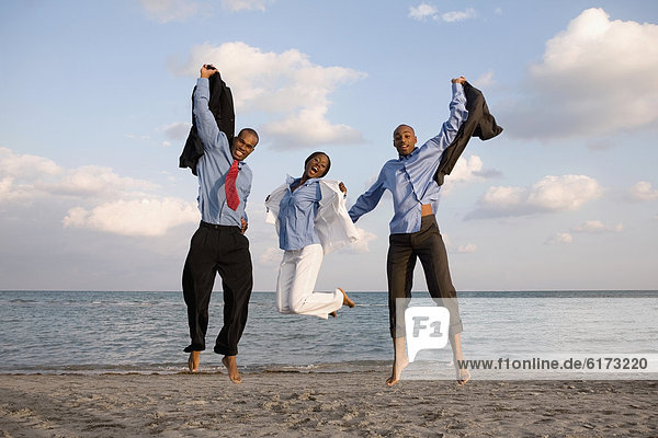 African businesspeople cheering at beach