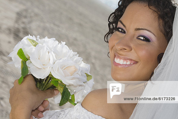 Hispanic bride holding bouquet