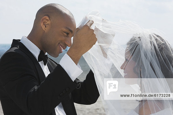 African groom lifting bride's veil