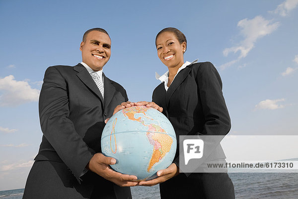 African businesspeople holding globe