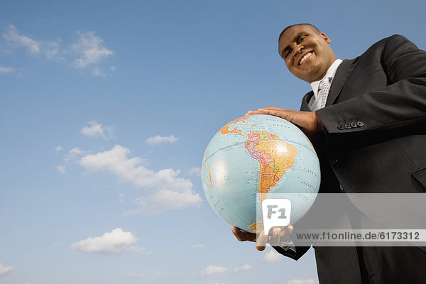 African businessman holding globe