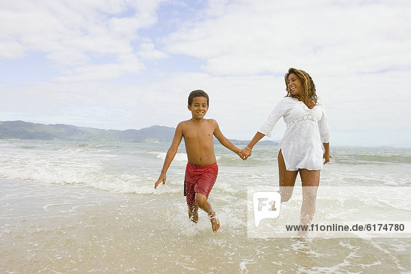 African mother and son running in the surf