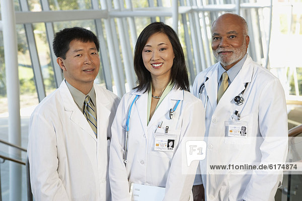 Young female Asian doctor with two middle-aged male doctors