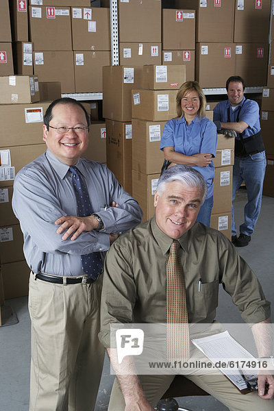 Businessmen with warehouse workers in warehouse