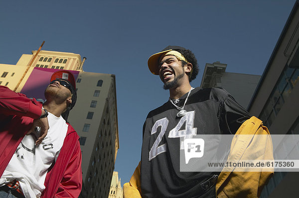 Low angle view of two young African men standing in urban area