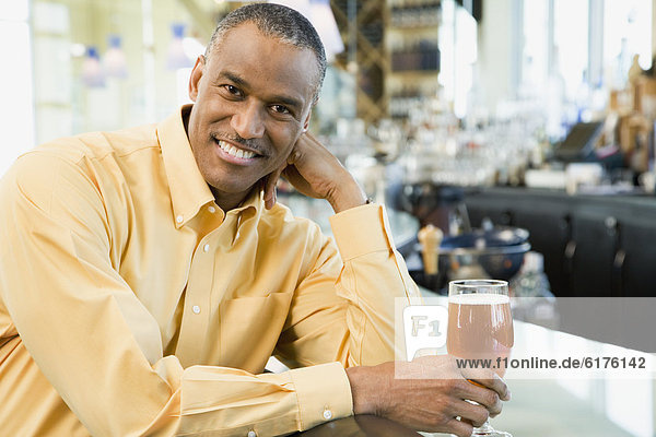 African American man with drink at bar