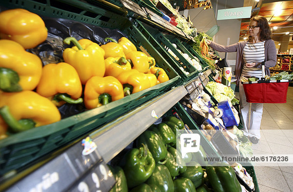 Frau kauft in der Obst- und Gemüseabteilung ein  Selbstbedienung  Lebensmittelabteilung  Supermarkt  Deutschland  Europa
