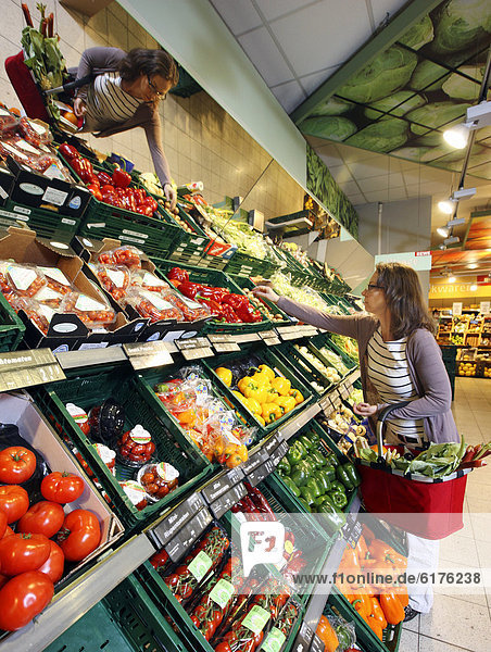Frau kauft in der Obst- und Gemüseabteilung ein  Selbstbedienung  Lebensmittelabteilung  Supermarkt  Deutschland  Europa