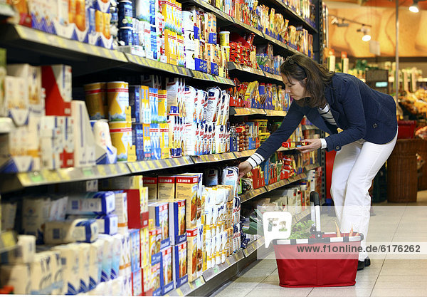 Woman purchasing flour and baking ingredients in a self-service grocery department  supermarket  Germany  Europe