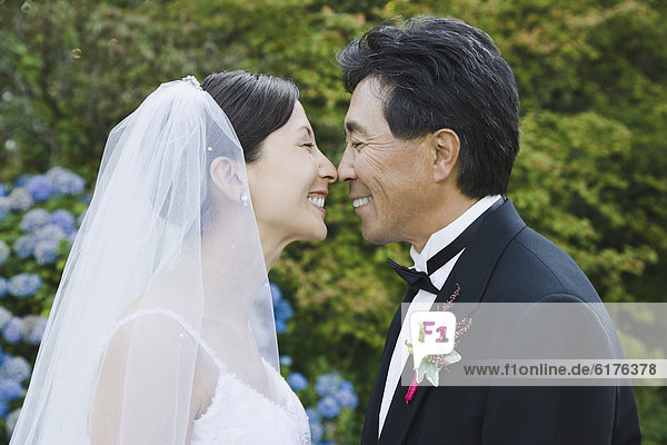 Asian newlyweds smiling at each other