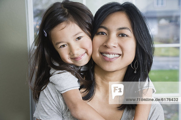 Mixed Race mother and daughter hugging