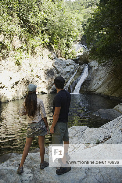 Hispanic couple looking at waterfall