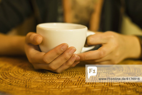 Close up of woman's hands holding tea mug
