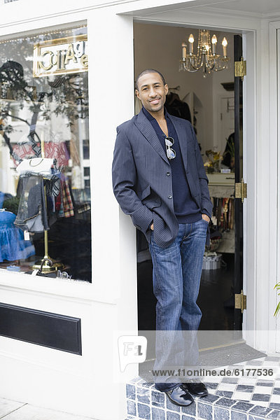 African American man standing in shop doorway