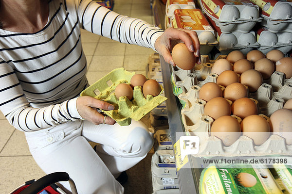 Frau kauft lose Hühnereier aus Freilandhaltung  Selbstbedienung  Lebensmittelabteilung  Supermarkt  Deutschland  Europa