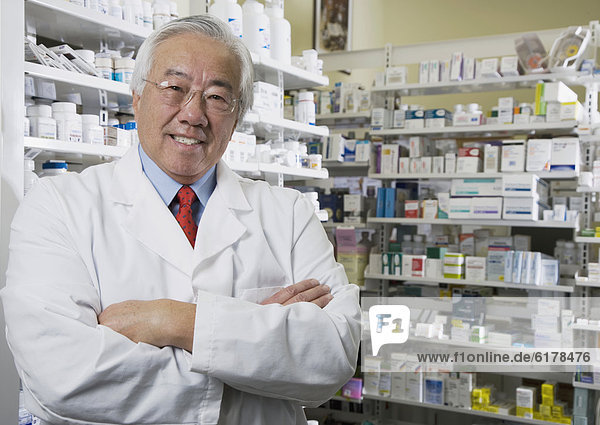 Senior Asian pharmacist with arms crossed