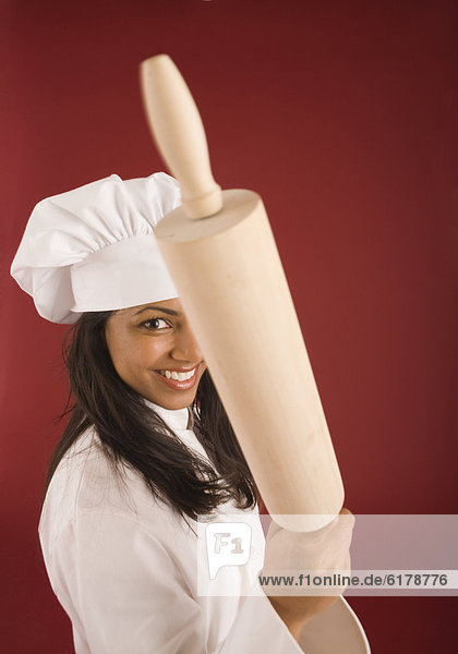 Indian female baker holding rolling pin