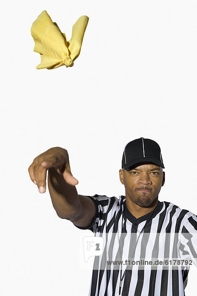 African male referee throwing flag