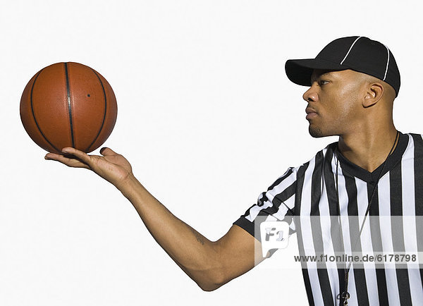 African male referee holding basketball
