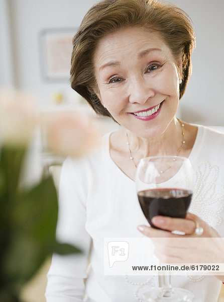 Japanese holding glass of red wine