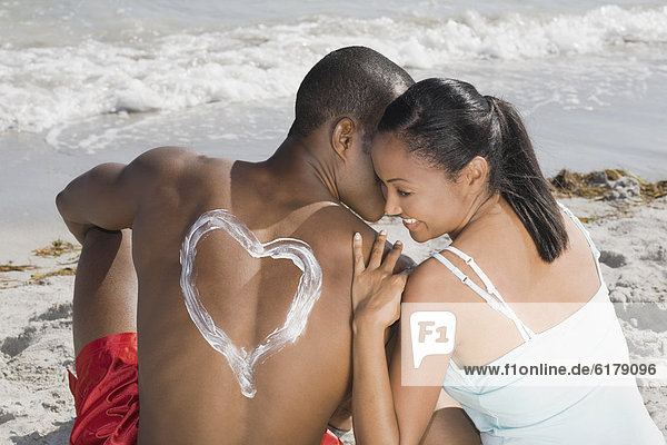 African man with sunscreen heart on back
