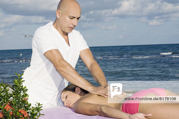 Hispanic woman receiving massage